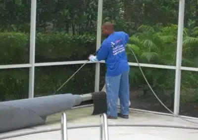 A man in blue shirt cleaning a pipe.