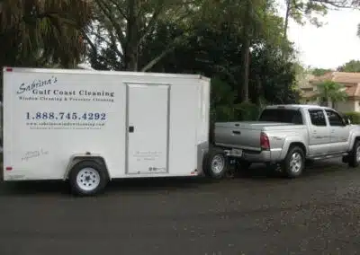 A truck pulling a trailer behind it on the street.
