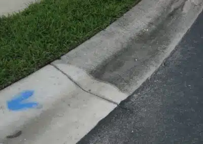 A sidewalk with blue paint on the side of it.
